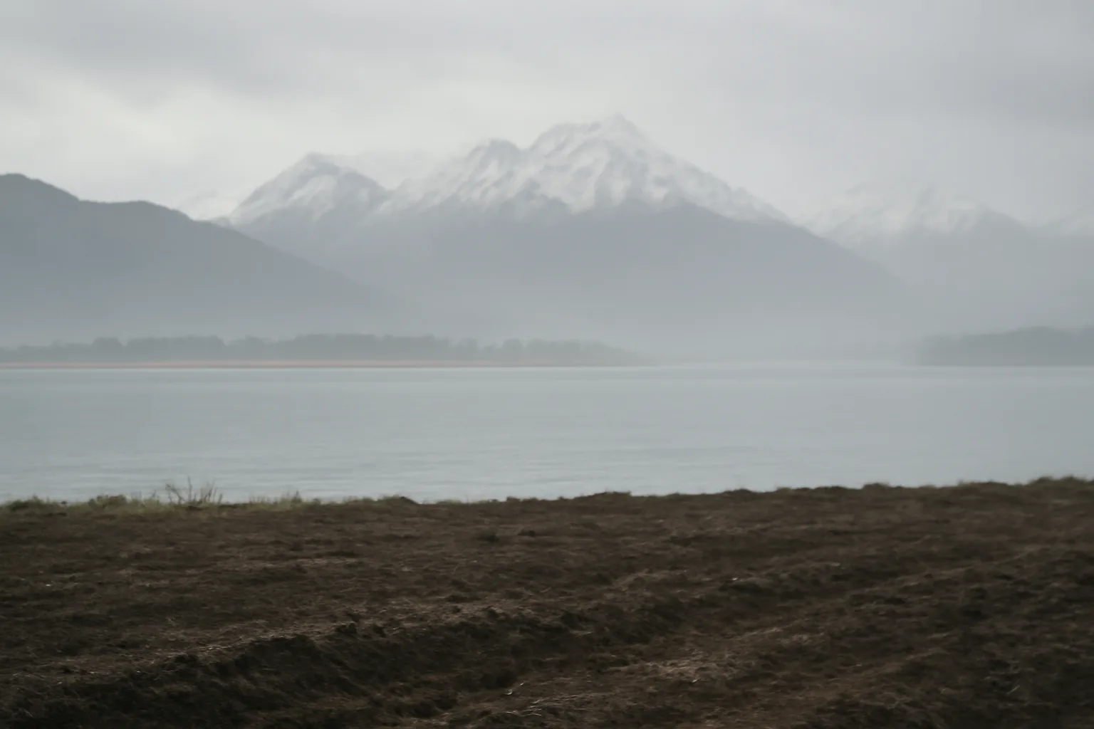 Alaskan landscape with damp soil and mountains, representing the future potential of human composting.